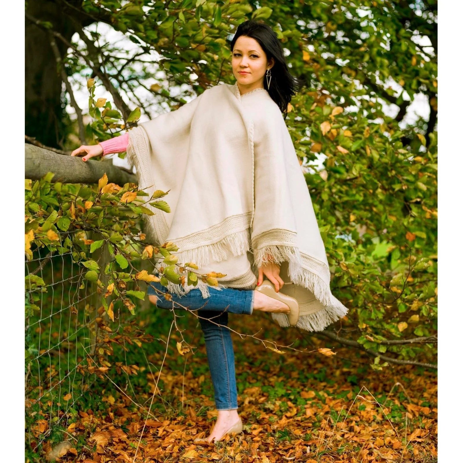 Alpaca Cape Wrap Poncho – Handcrafted, soft, and warm wrap made from luxurious alpaca fiber. Elegant, hypoallergenic, and perfect for versatile, stylish layering. Solid color in white being modeled by lady.